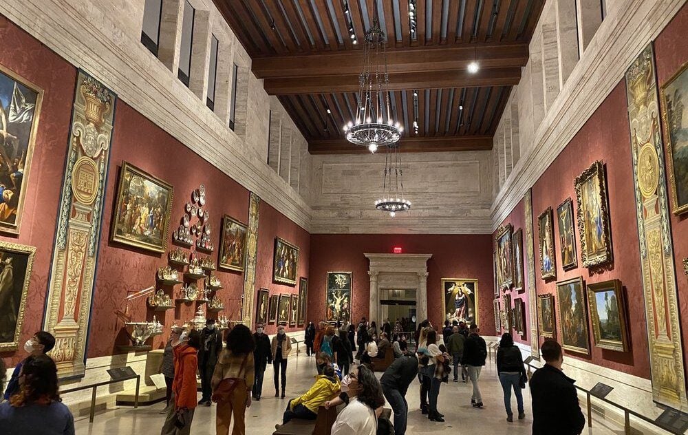 A group of people inside a gallery room with pink walls at the Museum of Fine Arts in Boston