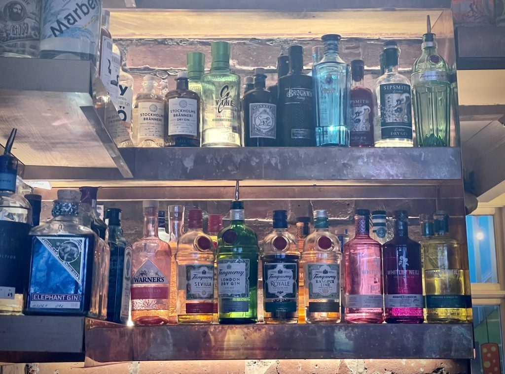 Two rows of gin bottles in a bar.