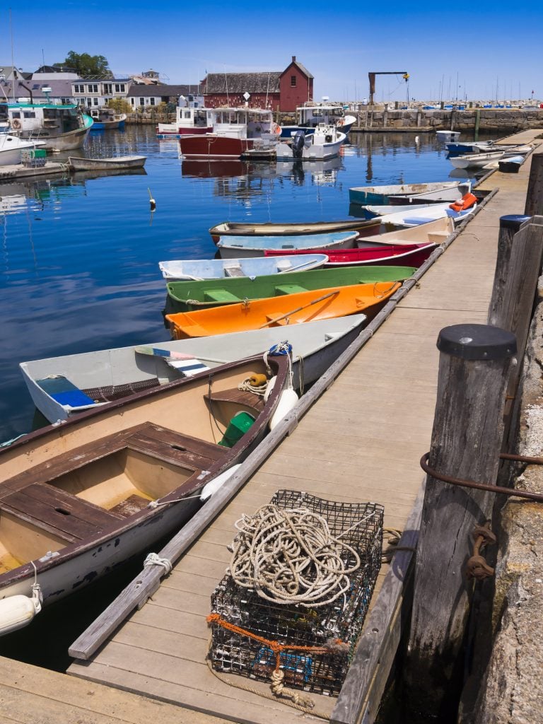 A row of brightly colored wooden boats next to a pier.