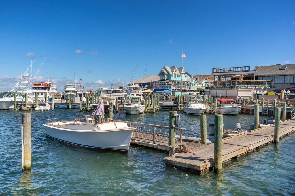 A port area with boats docked in front of cottages.