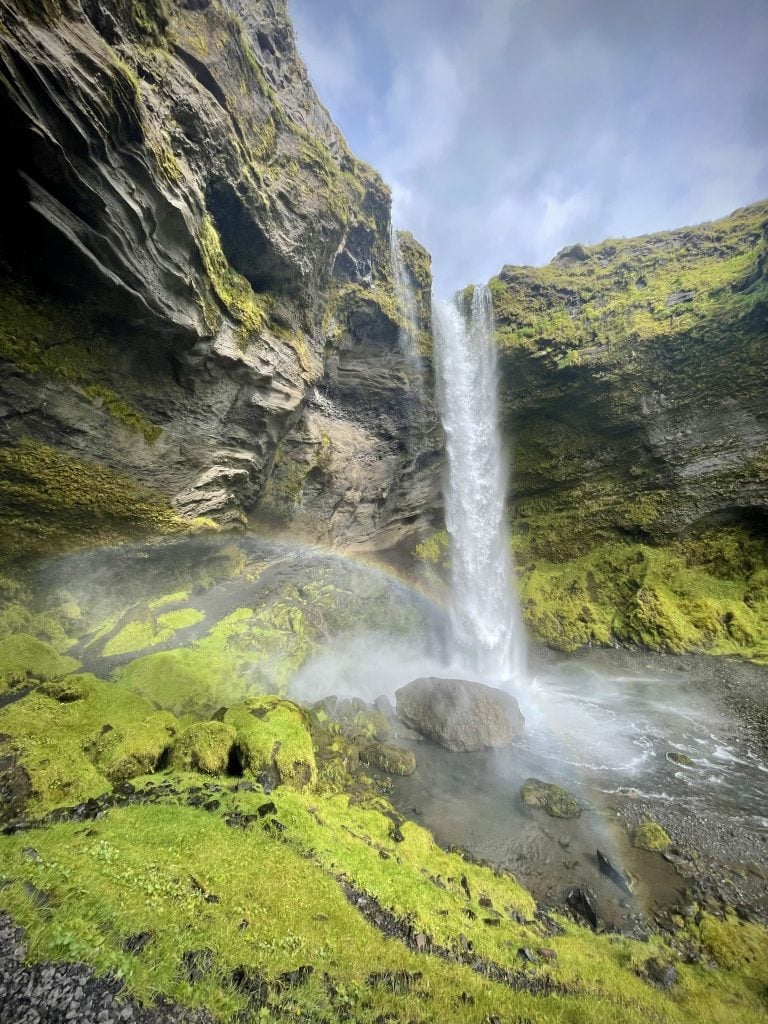 You see a faint rainbow curving along the bottom of Kvernufoss as the waterfall gently falls.