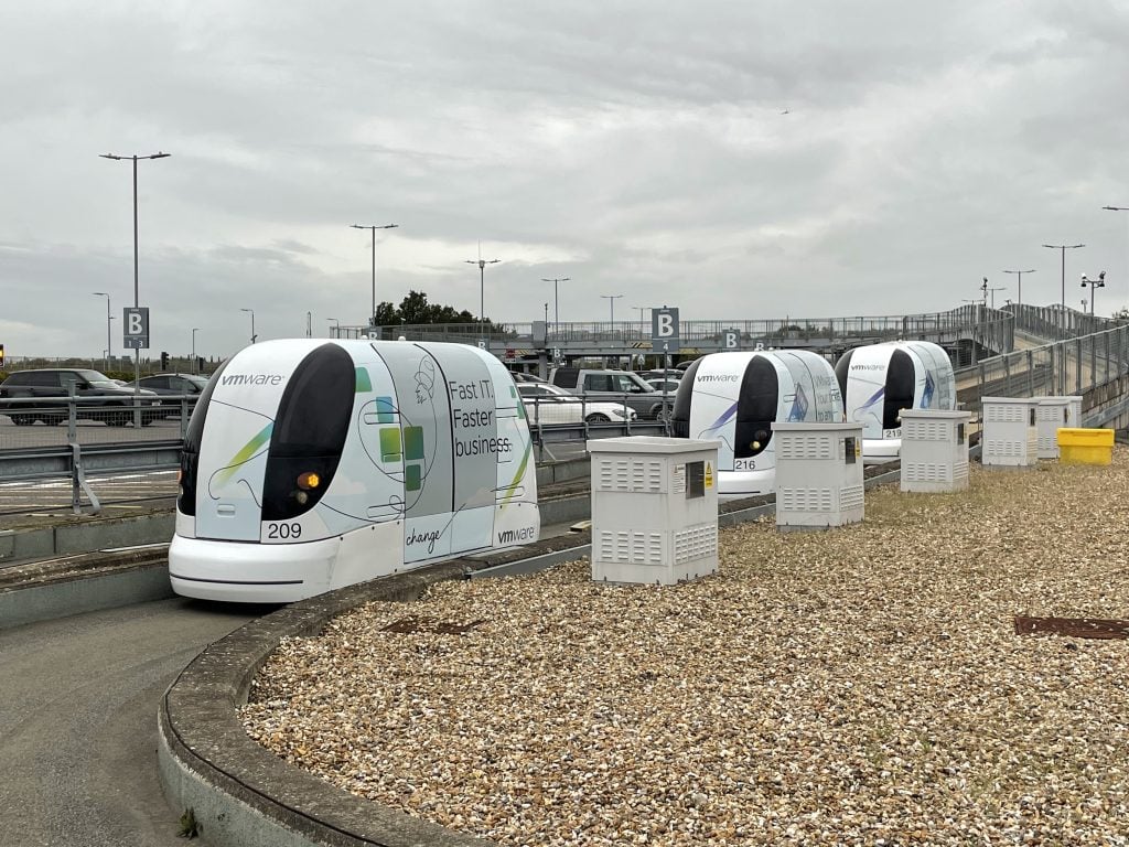 Small white pod cars driving on a track.