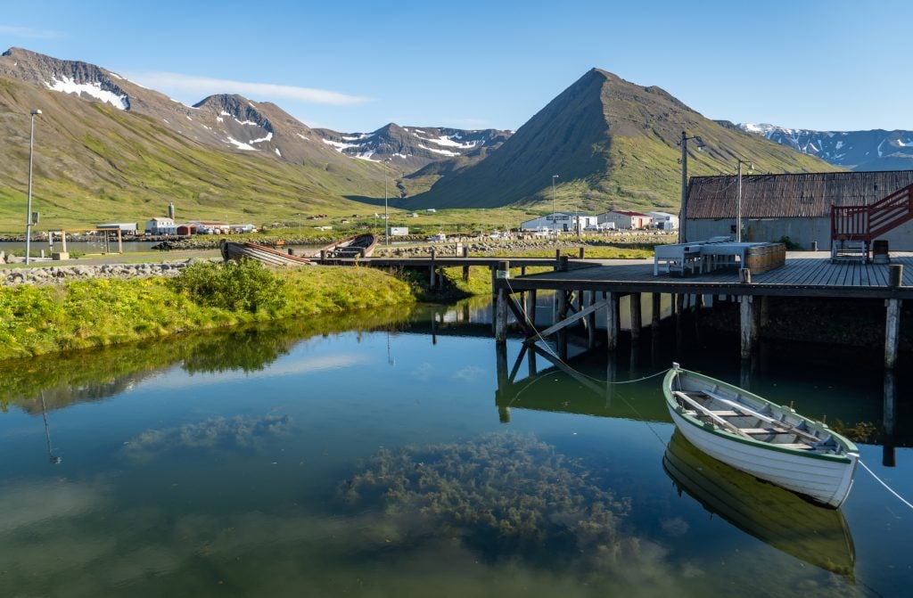 A lake next to a tiny mountain village.