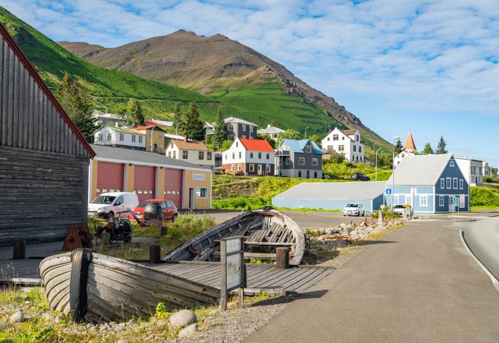 Brightly colored cottages against a bright green hill.