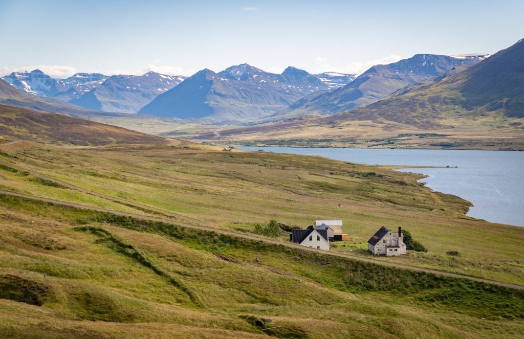 A view through the valley of crashing mountains and tiny cottages perched on hills.