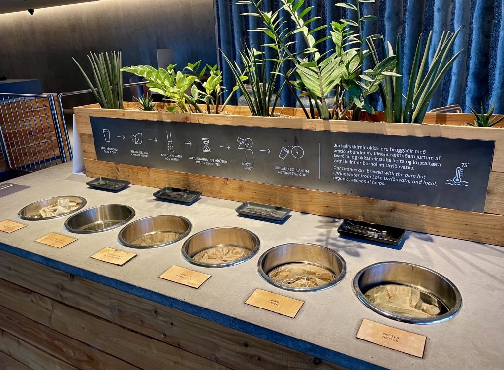 A counter with six round canisters filled with tea bags.