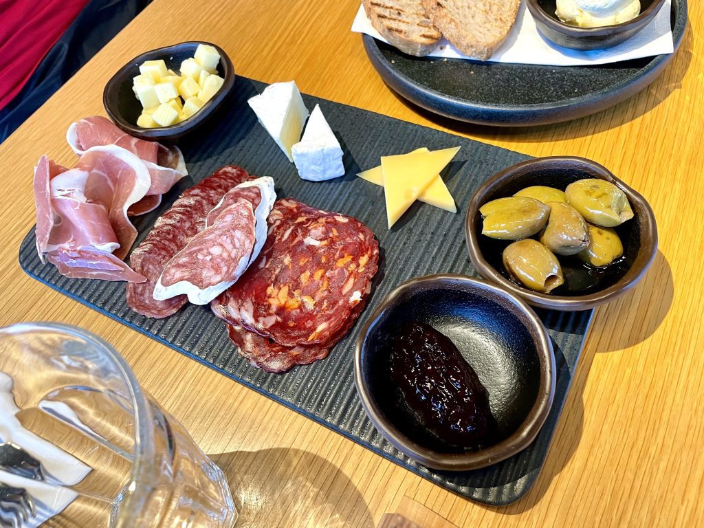 A charcuterie platter with various salamis and cheeses.