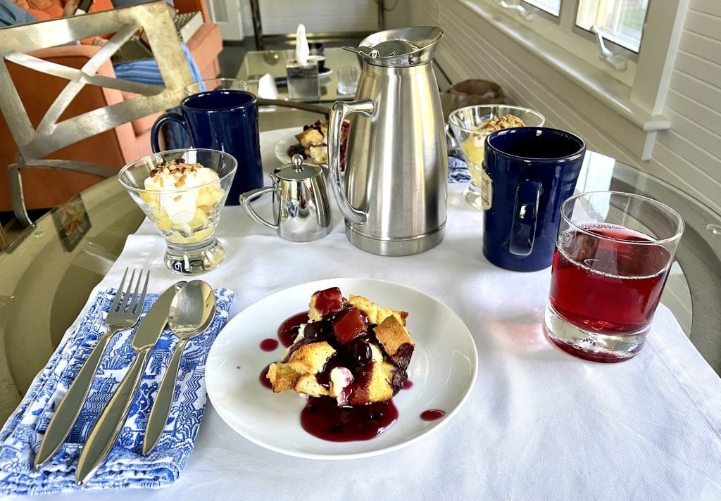 A plate of bread pudding topped with various berries.