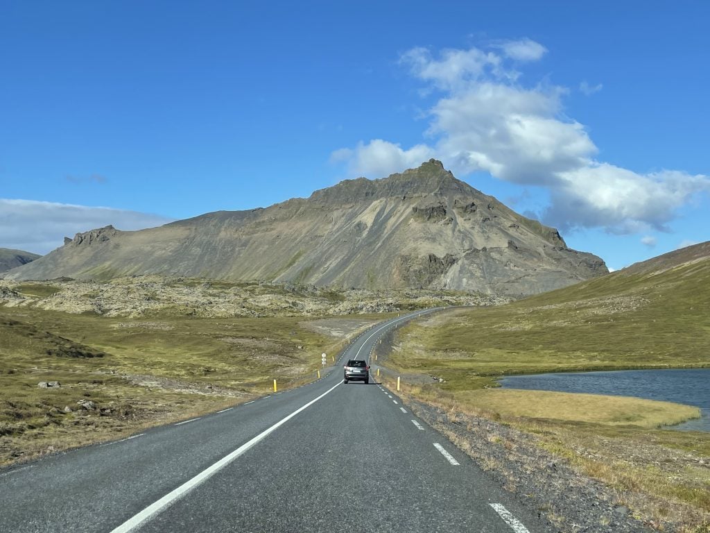 A car driving toward a mountain in Iceland.