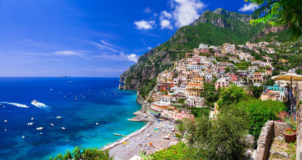 The Amalfi coast, with colorful buildings built into the steep hills leading down into the sea.