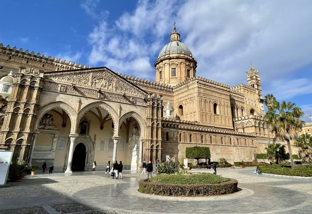 A church in Palermo with wild varied architecture -- porticoes, small baroque cupolas, a big dome, and lots of jagged bricks on the outside.