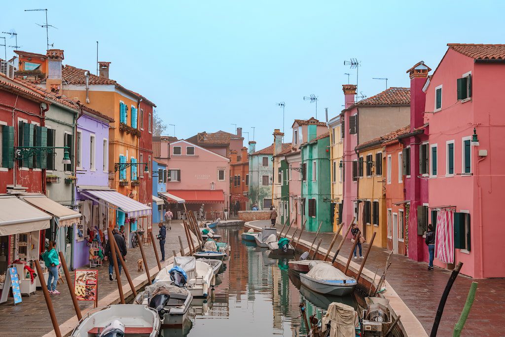 A canal in Burano Italy with colorful buildings on both sides