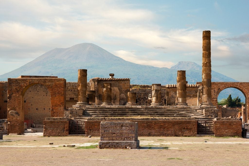 Pompeii Italy ruins with a volcano and clouds in the background