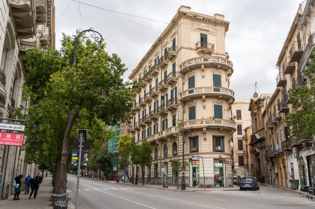 A tall skinny building on a narrow corner of Palermo.