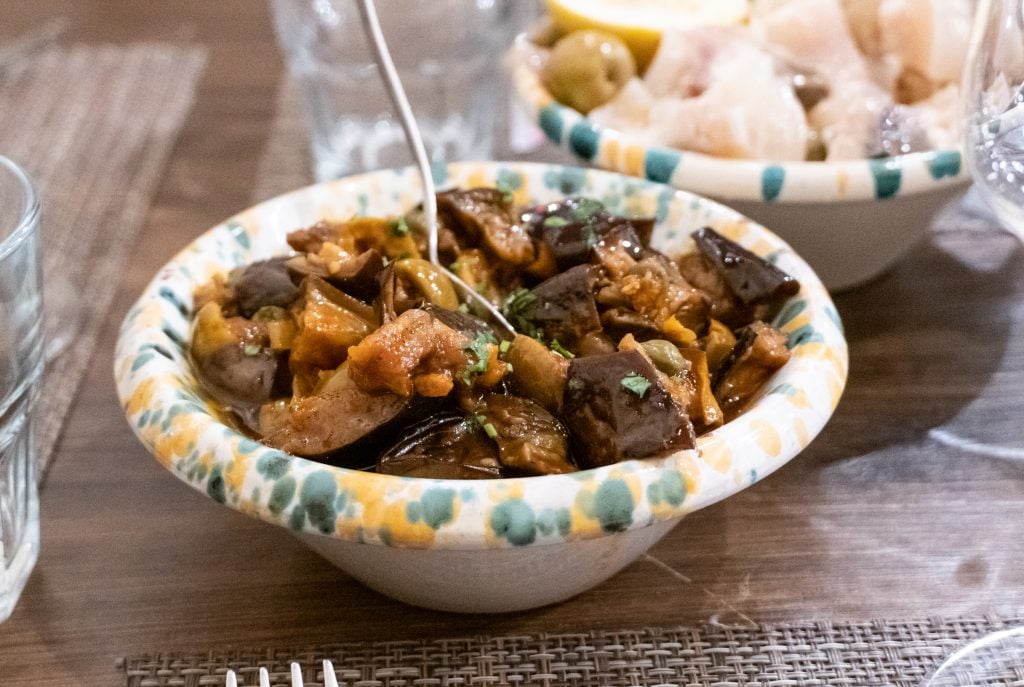 A bowl filled with caponata -- cold Sicilian vegetable stew with lots of eggplant.