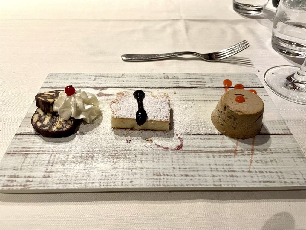 Three tiny cakes and semifreddos on a dessert plate.