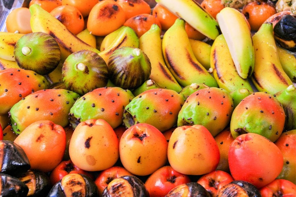 Marzipan candy shaped like gruit -- tiny bananas, oranges and figs.