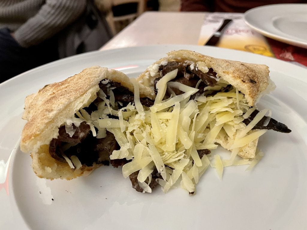 A flatbread sandwich filled with veal lung and grated cheese.
