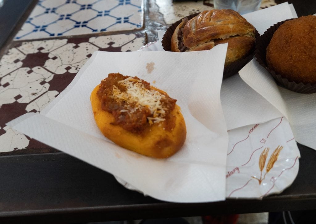 A small piece of pizza bread topped with tomato sauce and grated cheese.