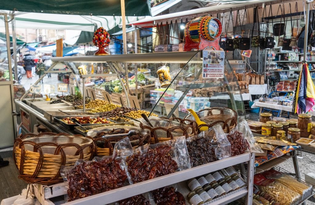 Market stalls stocked with all kinds of Sicilian food products.