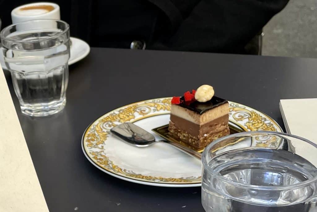 A small brown multilayered cake on a saucer.