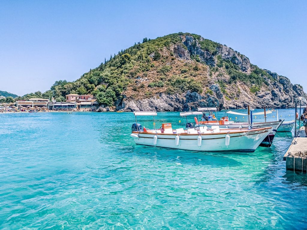 A boat in turquoise water at Palaiokastritsa, one of Corfu's most famous beaches.