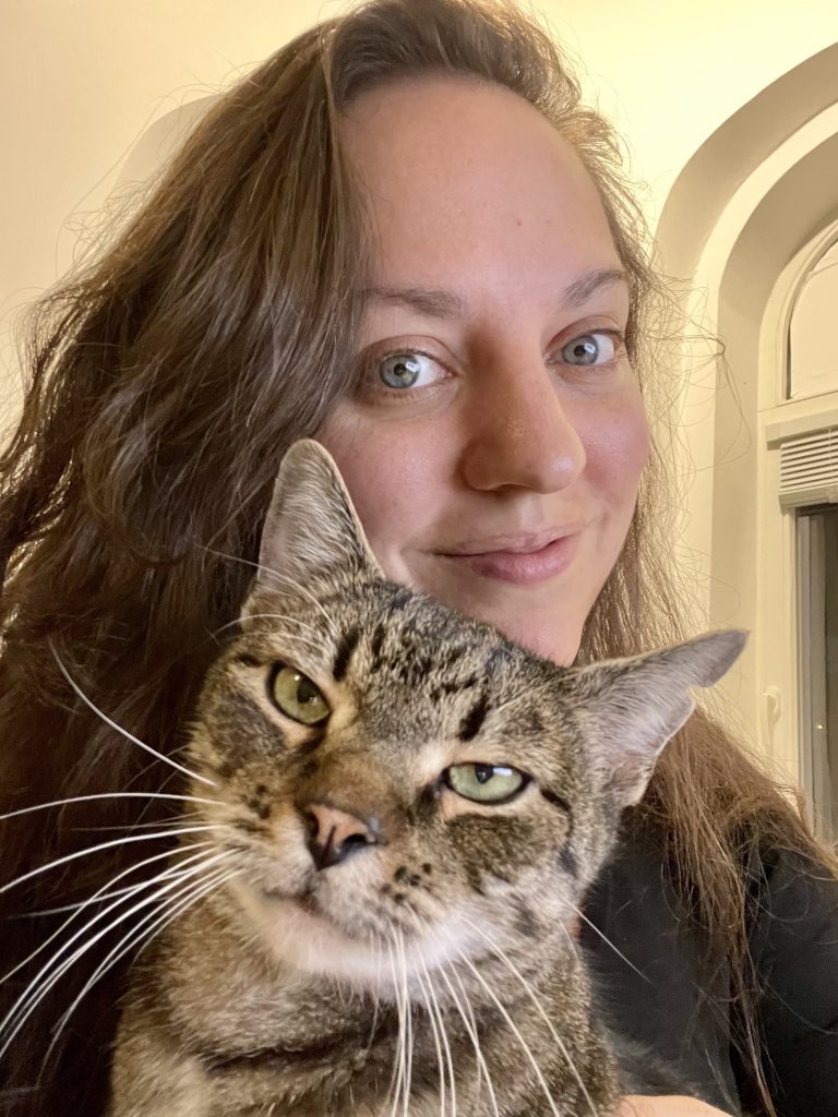 Kate takes a selfie with her an Balicek the brown tabby cat with green eyes.