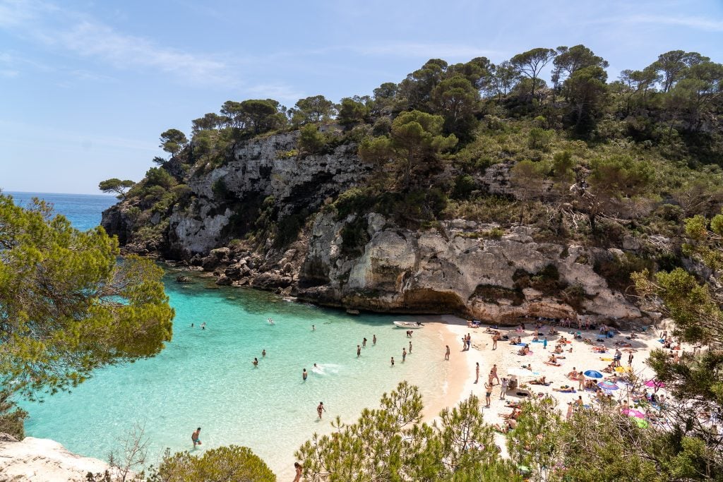 A cover with light blue water and white sand in Menorca, one of the best Mediterranean Islands to visit