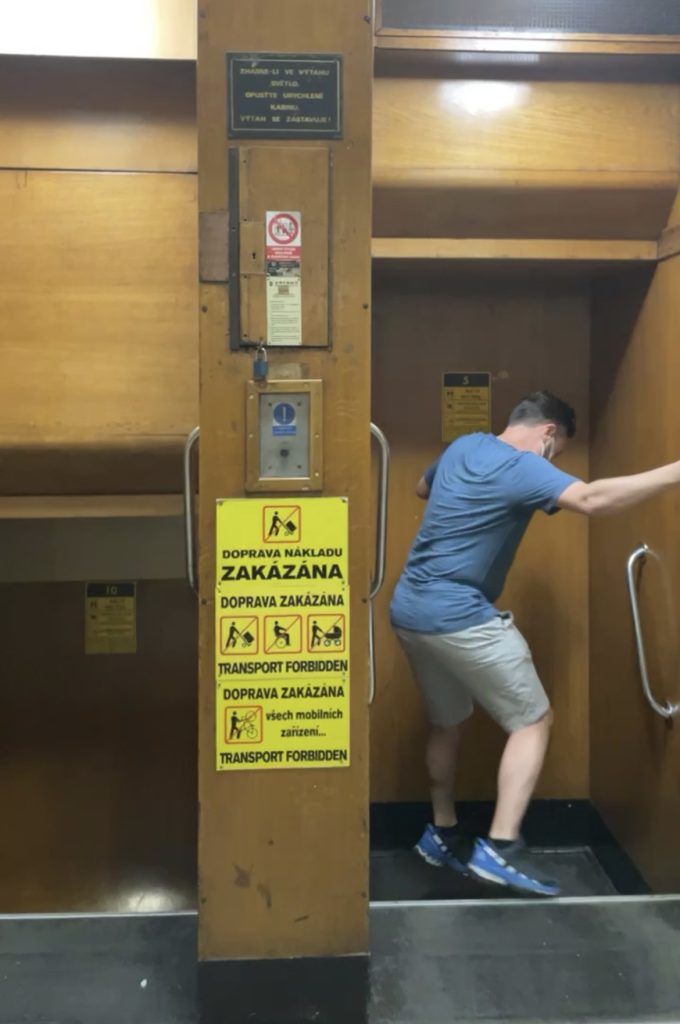Charlie jumps into an open paternoster elevator.