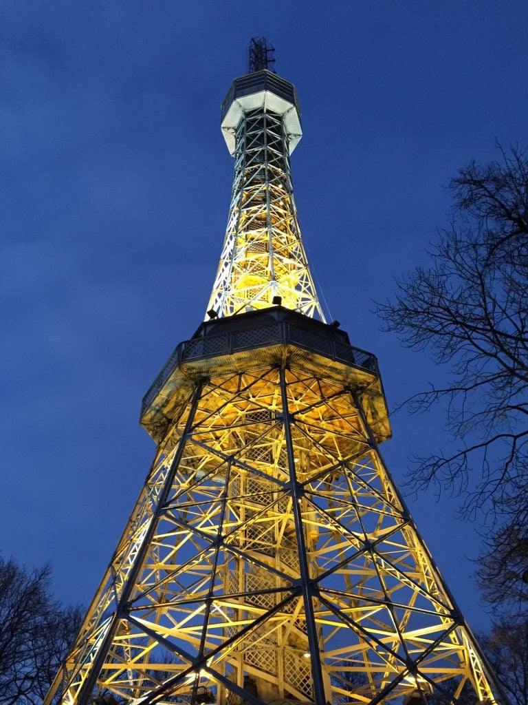 An Eiffel Tower-like building lit up against a dark blue night sky.
