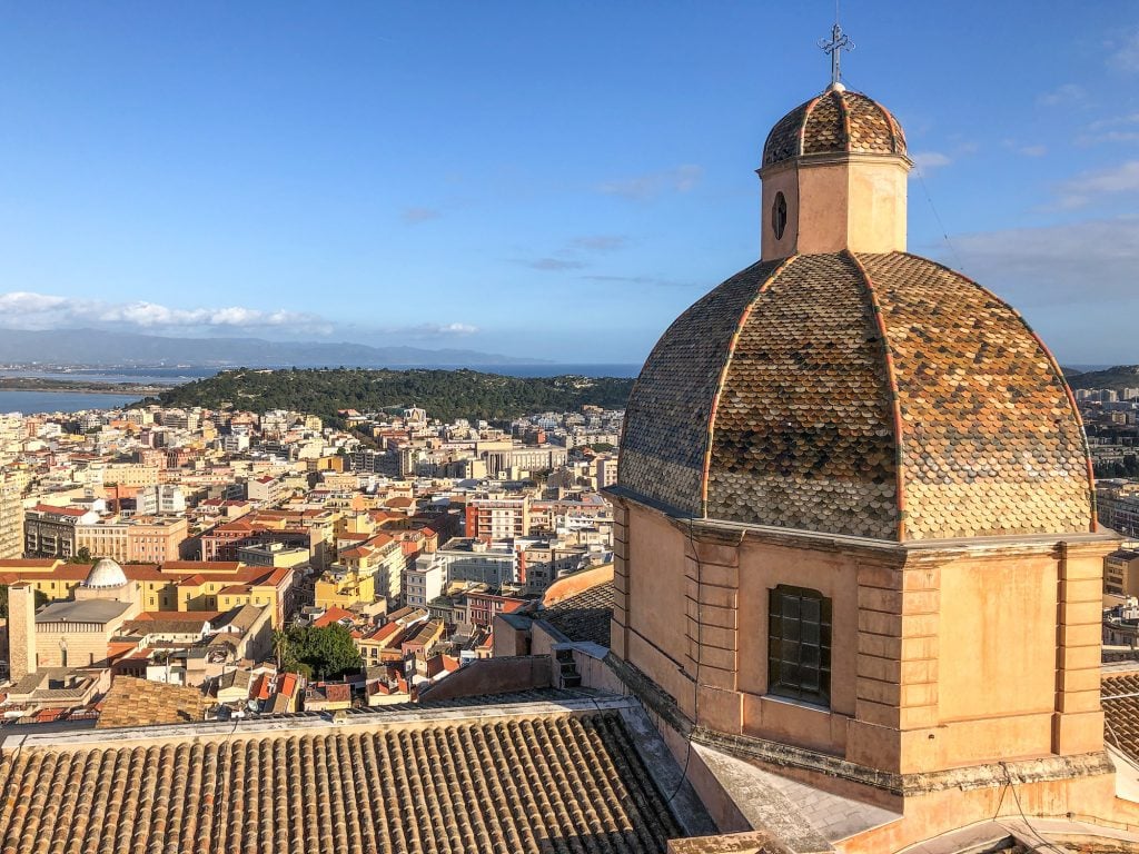 Aerial view from behind a church dome looking out over a town on Sardinia