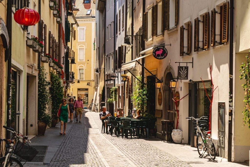 An empty street in Bolzano Italy with chairs outside a cafe