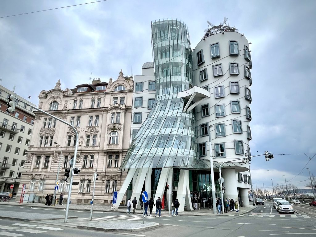 The dancing house in Prague: a building that looks like two figures, one stately and tall, and one leaning back with a full skirt.