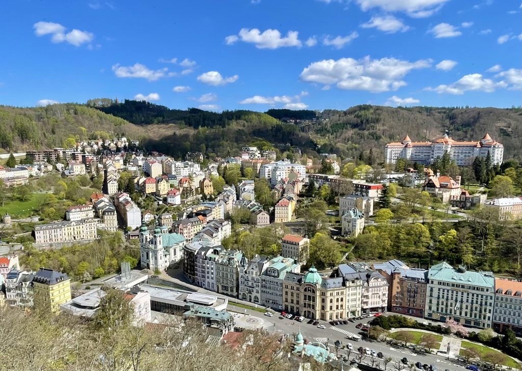 A view from above of Karlovy Vary, with pastel-colored buildings nestled into the hills.