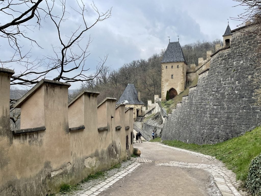 A path leading to a castle tower underneath a stormy gray sky.