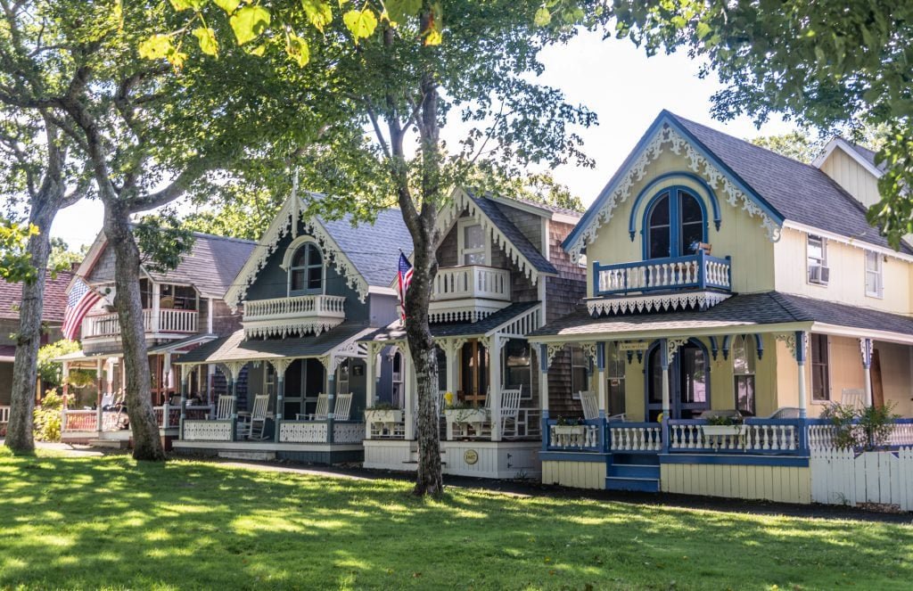 A row of four colorful gingerbread houses in a wooded area in Martha's Vineyard.