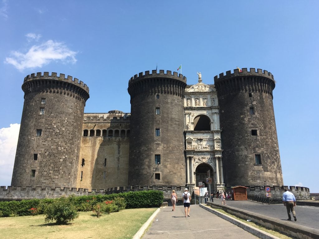 A stone castle with four rounded corner towers in Naples, Italy.