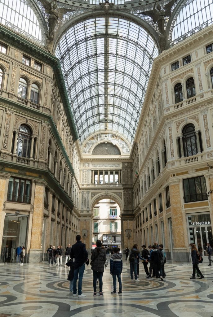 A fancy indoor shopping colonnade with big rounded glass windows as skylights.