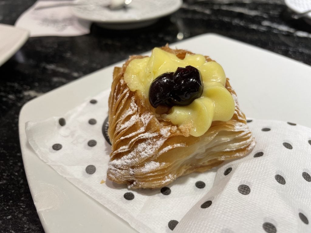 A sfogliatella, or lobster tail pastry, with layers of crisp pastry dough and cream on top.