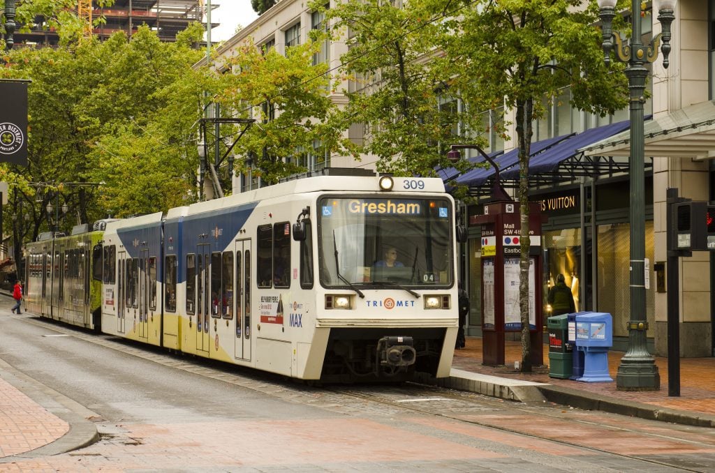 Portland's streetcar -- a modern tram -- perched at a stop.