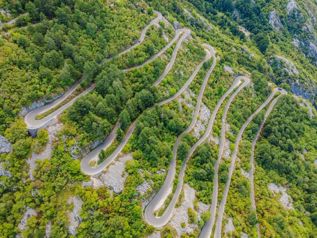 A long, squiggly road inching up a steep mountain.