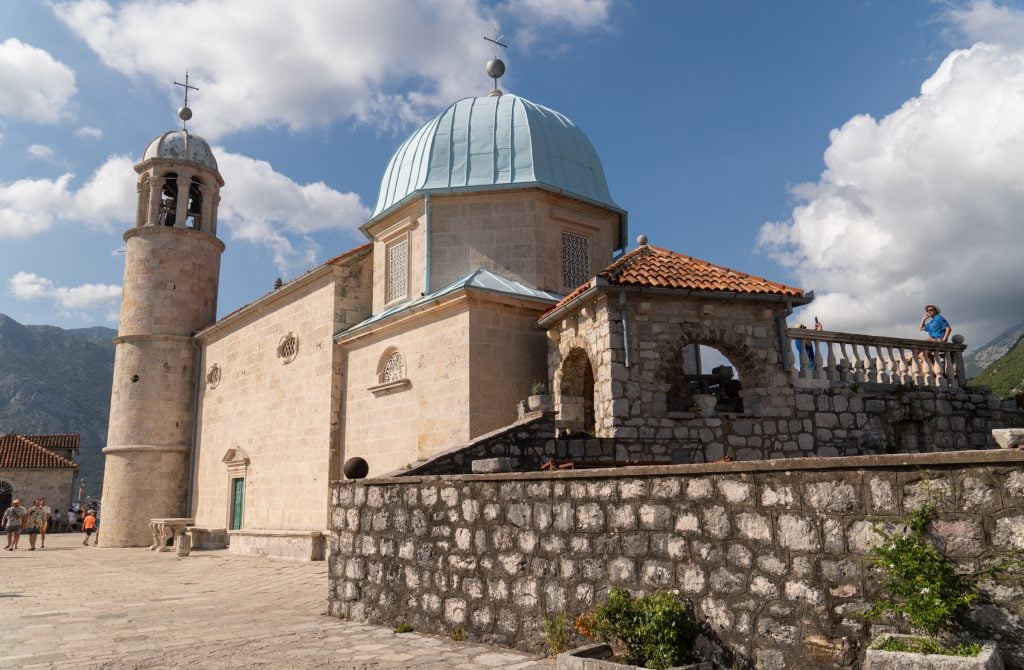 A tiny chapel with a blue dome and bell tower built on an island in the Adriatic.