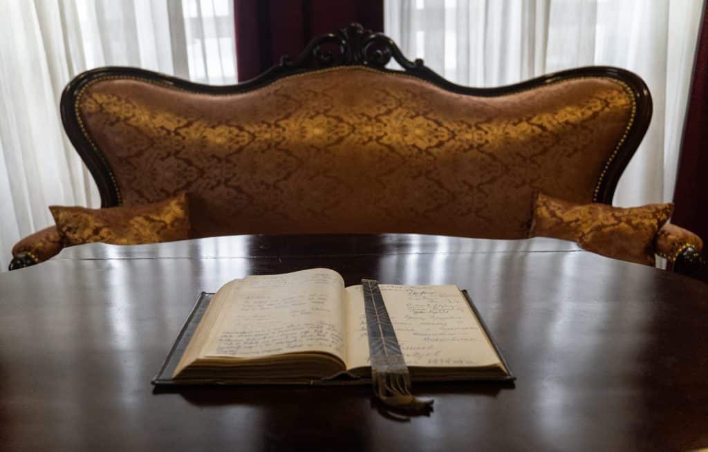 Inside the Perast Museum, an open book with writing in it on a shiny wooden table.