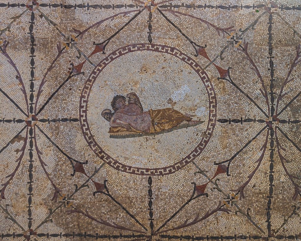 A detailed mosaic with the Roman God Nymphos lounging seductively in a robe.