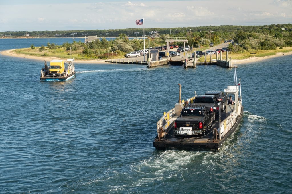 Un minuscule ferry ne pouvant accueillir que trois voitures traverse un chenal étroit jusqu'à l'île de Chappaquiddick.