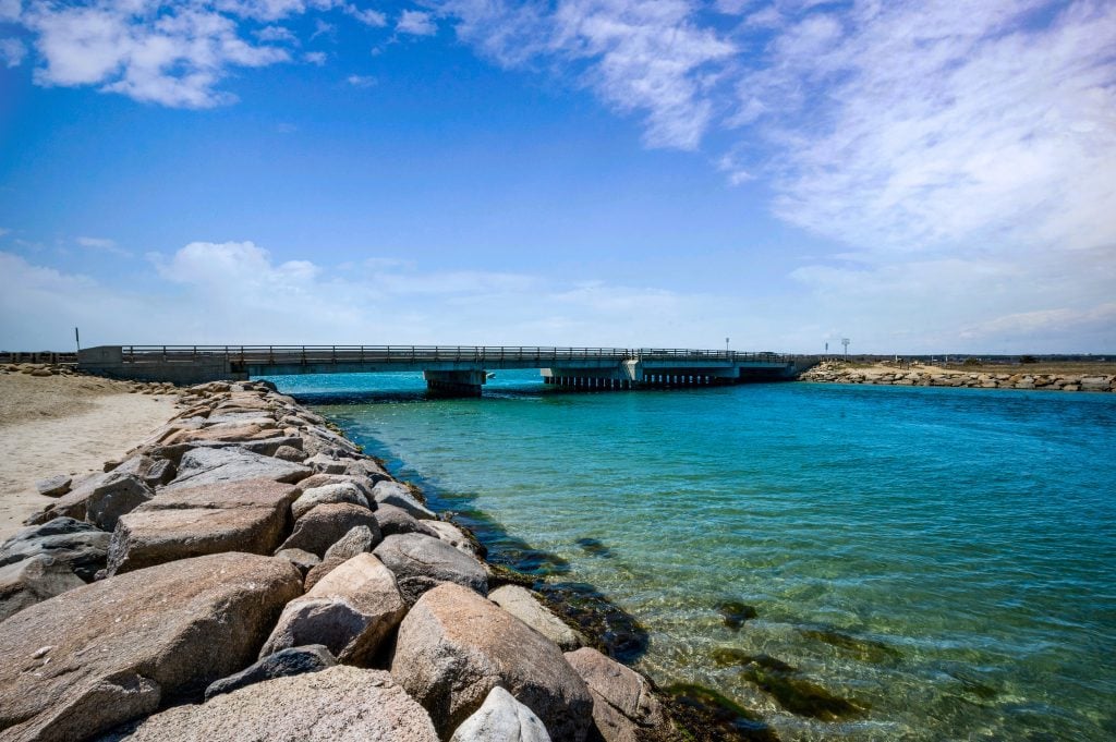 A low cement bridge hanging over a channel of bright blue water in Martha's Vineyard.