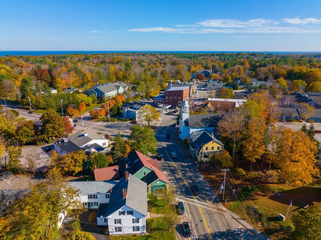 An aerial view of the town of York, with little wooden buildings surrounded by orange trees during foliage season.