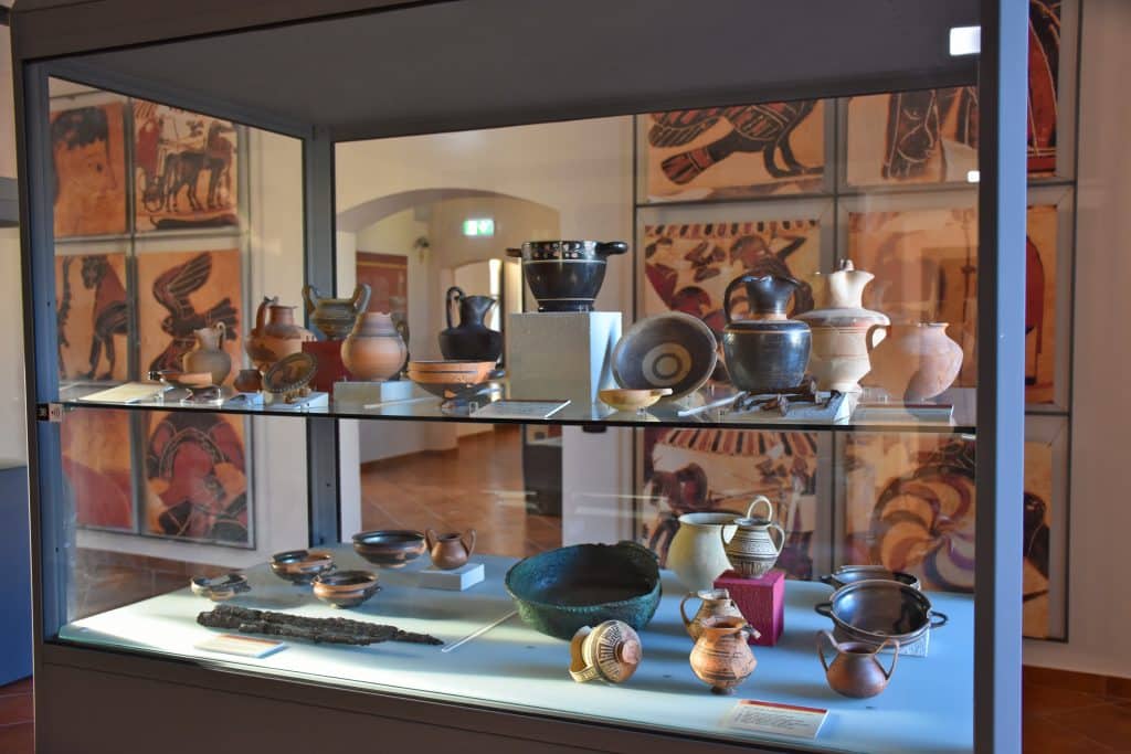 A display case filled with ancient pots and jars.