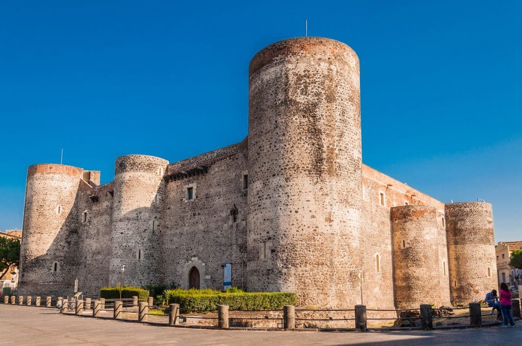 An old stone castle with rounded towers on each corner.