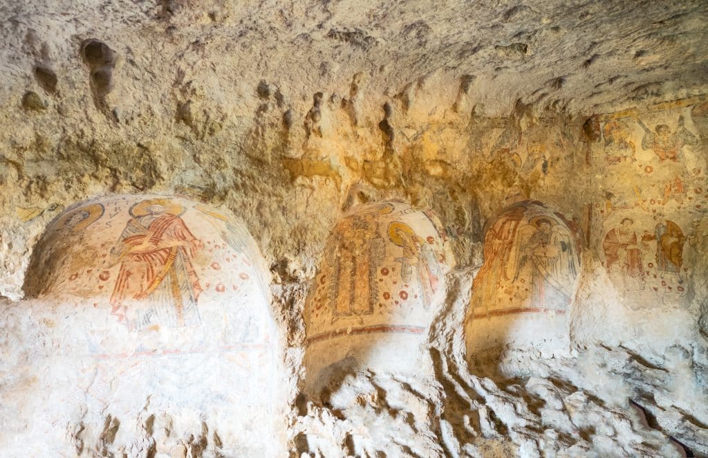 A cave filled with paintings of saints in Matera Italy.